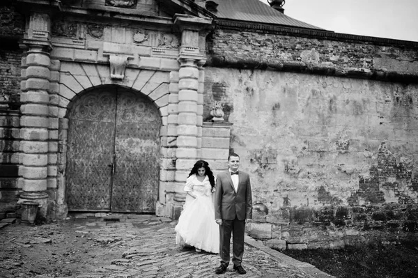 Impresionante pareja de boda posando junto a las antiguas puertas de una ca —  Fotos de Stock