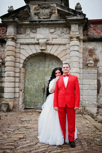 Impresionante pareja de boda posando junto a las antiguas puertas de una ca — Foto de Stock