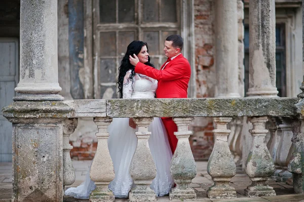 Pareja de bodas bien parecido posando en el balcón de un viejo edificio —  Fotos de Stock