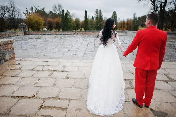 美しい結婚式のカップルが雨の歩道の上を歩くと — ストック写真