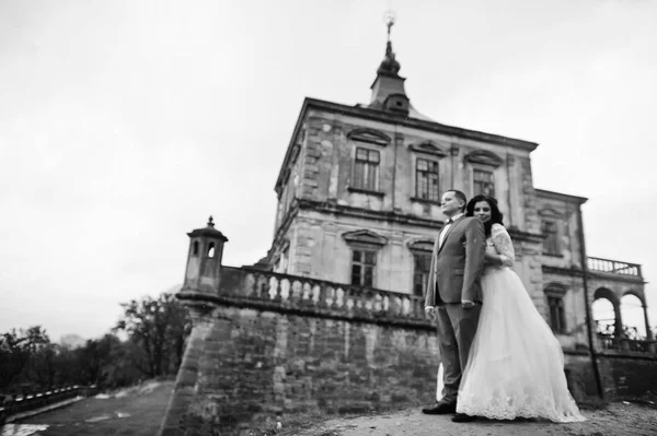 Hermosa pareja de boda de pie fuera con un hermoso archi —  Fotos de Stock