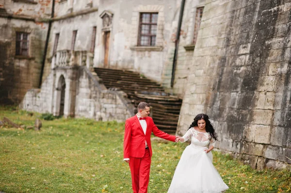 Bella coppia di sposi in piedi fuori con una bella archi — Foto Stock