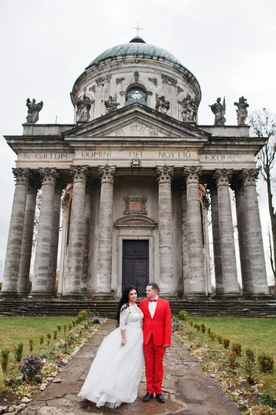 Couple de mariage étreignant contre chucrhe baroque en arrière-plan . — Photo