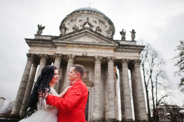 Couple de mariage étreignant contre chucrhe baroque en arrière-plan . — Photo