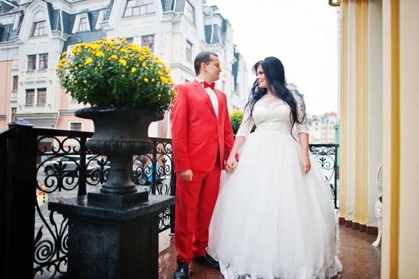 Pareja de boda tomados de la mano en la terraza con flores en el —  Fotos de Stock