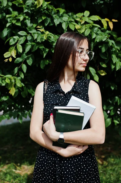 Portret van een verlegen jonge vrouw in zwarte polka dot jurk en glas — Stockfoto