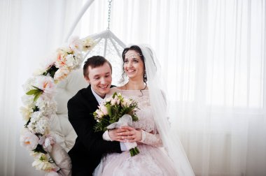 Evlilik çift çiçek salıncak stüdyoda oturup....