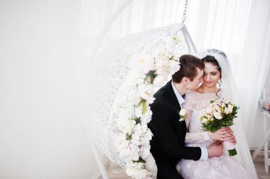 Evlilik çift çiçek salıncak stüdyoda oturup....