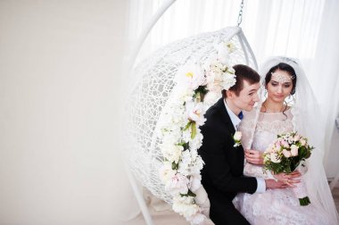 Evlilik çift çiçek salıncak stüdyoda oturup....