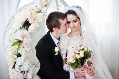 Evlilik çift çiçek salıncak stüdyoda oturup....