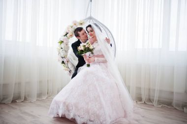 Evlilik çift çiçek salıncak stüdyoda oturup....