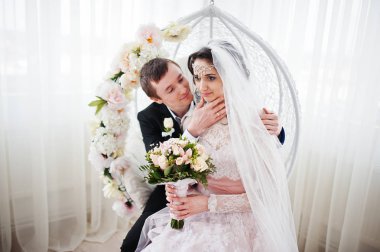 Evlilik çift çiçek salıncak stüdyoda oturup....