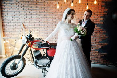 Muhteşem Düğün çifti bir ro büyük bir eski Motosiklet ile poz