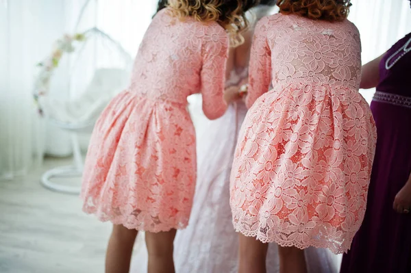 Helpful bridesmaids and mother helping bride to tie the dress up — Stock Photo, Image