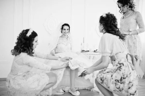 Tärnorna hjälpa bruden att sätta sitt bröllop skor och få re — Stockfoto
