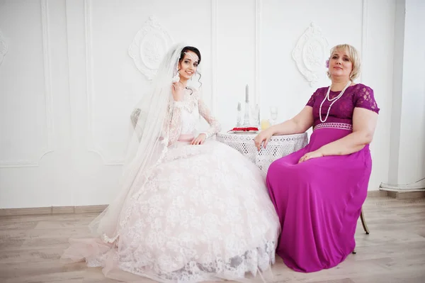 ポーズ紫で母親と一緒にウェディング ドレスの美しい花嫁 — ストック写真