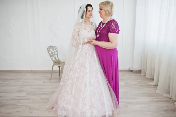 ポーズ紫で母親と一緒にウェディング ドレスの美しい花嫁 — ストック写真