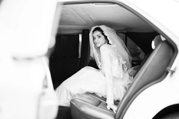 Tökéletes menyasszony menyasszonyi autóban ül. Fekete-fehér fénykép. — Stock Fotó