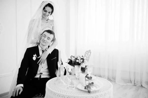 Приваблива наречена стоїть поруч з нареченим, коли він сидить — стокове фото