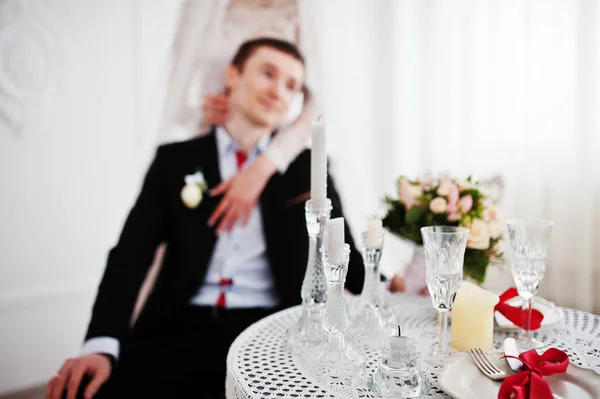 Noiva atraente em pé ao lado do noivo enquanto ele está sentado — Fotografia de Stock