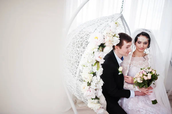 Evlilik çift çiçek salıncak stüdyoda oturup....