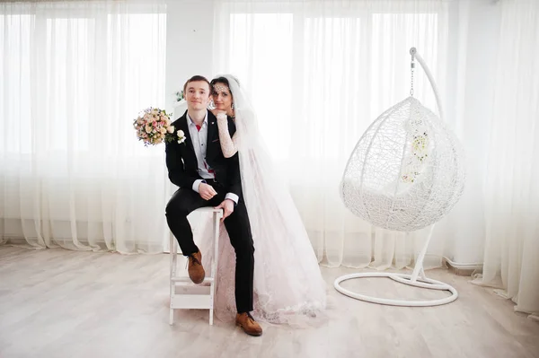 Свадебная пара позирует в светло-белой студии . — стоковое фото