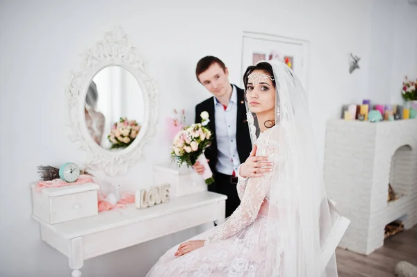 Esküvői pár pózol a könnyű fehér stúdió. — Stock Fotó