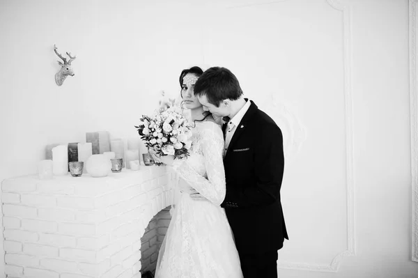 Casamento casal posando no estúdio branco claro. Preto e branco — Fotografia de Stock