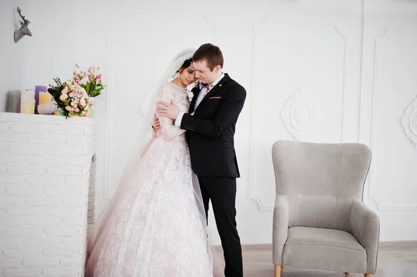Bröllopsparet poserar i ljus vit studion. — Stockfoto