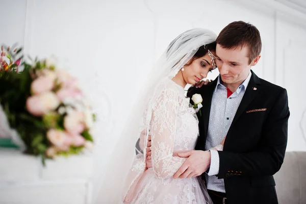 Pareja de boda posando en el estudio blanco claro . — Foto de Stock