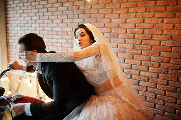 Amazing wedding couple posing with a huge old motorcycle in a ro — Stock Photo, Image