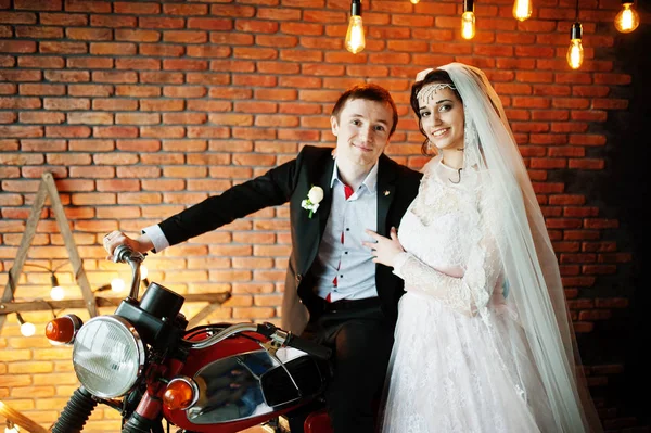 Fantastiska bröllop par poserar med en enorm gamla motorcykel i en ro — Stockfoto