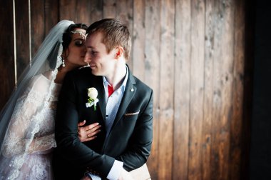 İnanılmaz evlilik çift ahşap arka plan üzerinde sarılma. Rustik 