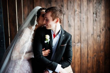 İnanılmaz evlilik çift ahşap arka plan üzerinde sarılma. Rustik 