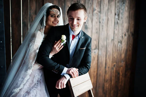 Geweldige bruidspaar knuffelen op de houten achtergrond. Rustiek — Stockfoto