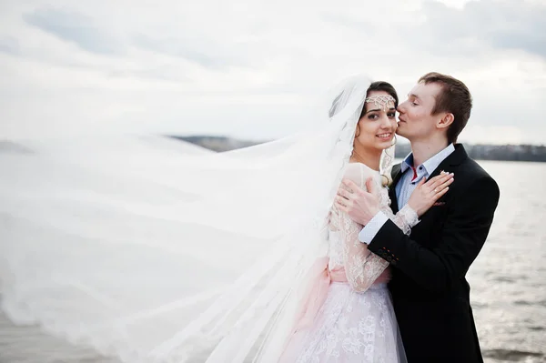 Couple nouvellement marié marchant et posant au bord du lac sur leur — Photo