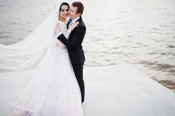 Couple nouvellement marié marchant et posant au bord du lac sur leur — Photo