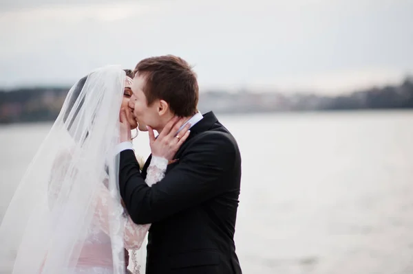 Nahaufnahme eines küssenden Hochzeitspaares am Seeufer. — Stockfoto