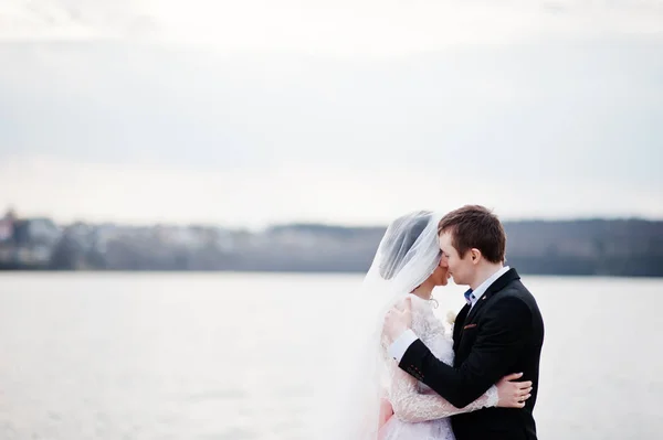 Close-up foto van een kussen bruidspaar op de oever van het meer. — Stockfoto