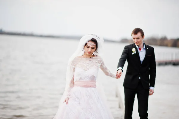 Πρόσφατα παντρεμένος ζευγάρι περπάτημα και ποζάρει στην όχθη της λίμνης στο τους — Φωτογραφία Αρχείου