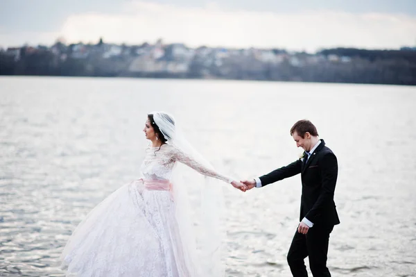 Pas getrouwd paar wandelen en poseren op de oever van het meer op hun — Stockfoto