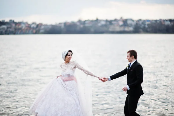 Pareja recién casada caminando y posando en la orilla del lago en su —  Fotos de Stock