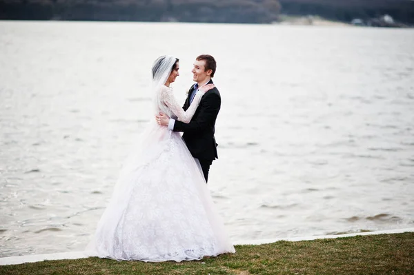新婚夫妇步行，并构成了湖边上他们 — 图库照片