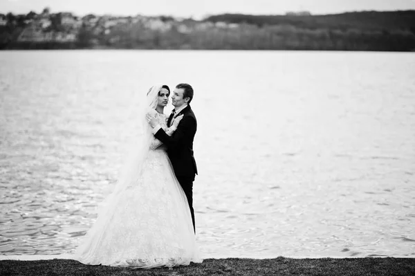 Casamento recém-casado casal andando e posando ao lado do lago em sua — Fotografia de Stock