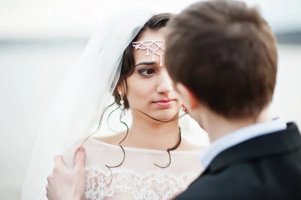 Brudparet tittar in i varandras ögon med sjön på b — Stockfoto
