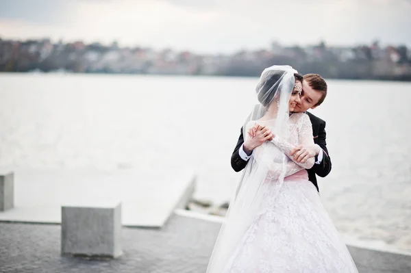 Pareja recién casada caminando y posando en la orilla del lago en su —  Fotos de Stock
