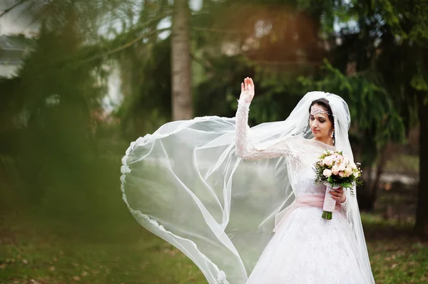 Portrait of a pretty bride posing in the park with a bouquet on — Stock Photo, Image