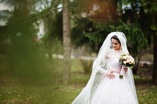 Portrét krásné nevěsty pózuje v parku s kyticí na — Stock fotografie