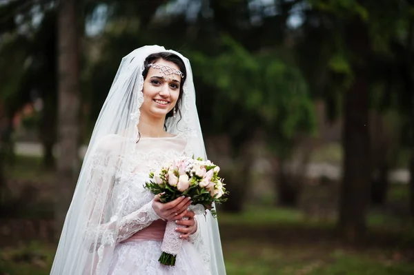 A szép menyasszony, pózol a parkban, egy-egy csokor a portréja — Stock Fotó