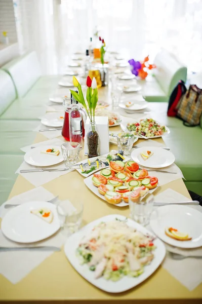 Deliciosas comidas, como ensaladas y canapés colocados en la pestaña puesta — Foto de Stock